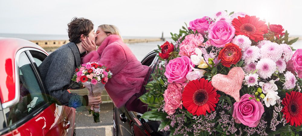 zwei küssende Personen und ein romantischer Blumenstrauß